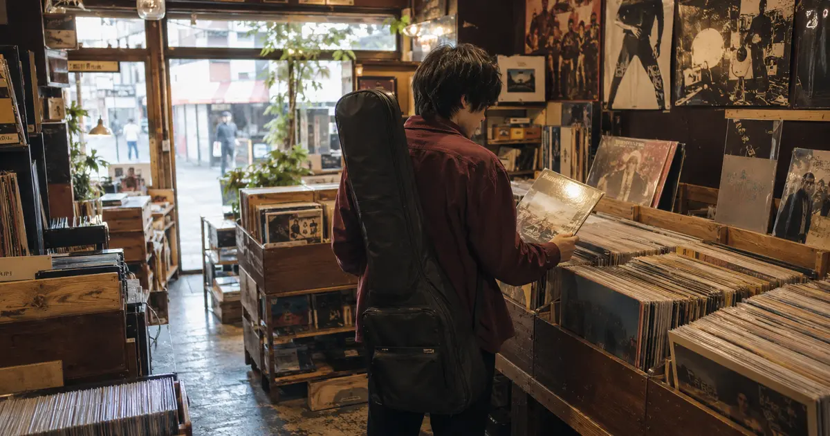 中古レコード店でギターケースを背負い、最初に弾きたい一枚を選ぶ初心者